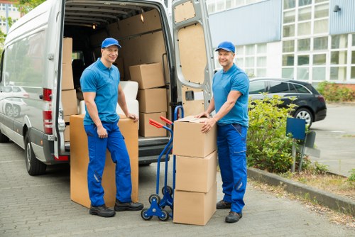 Packed boxes and furniture ready for collection by a removals van