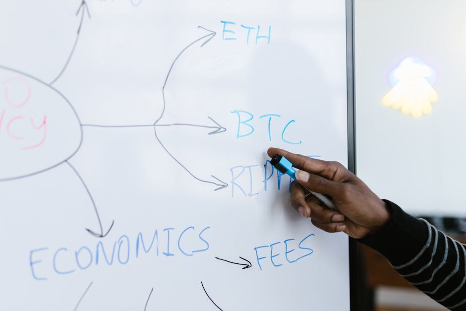A person holds a blue marker and points to a whiteboard with a diagram about cryptocurrency. The diagram features a central oval labeled 'CRYPTO CURRENCY' written in red, surrounded by various branche