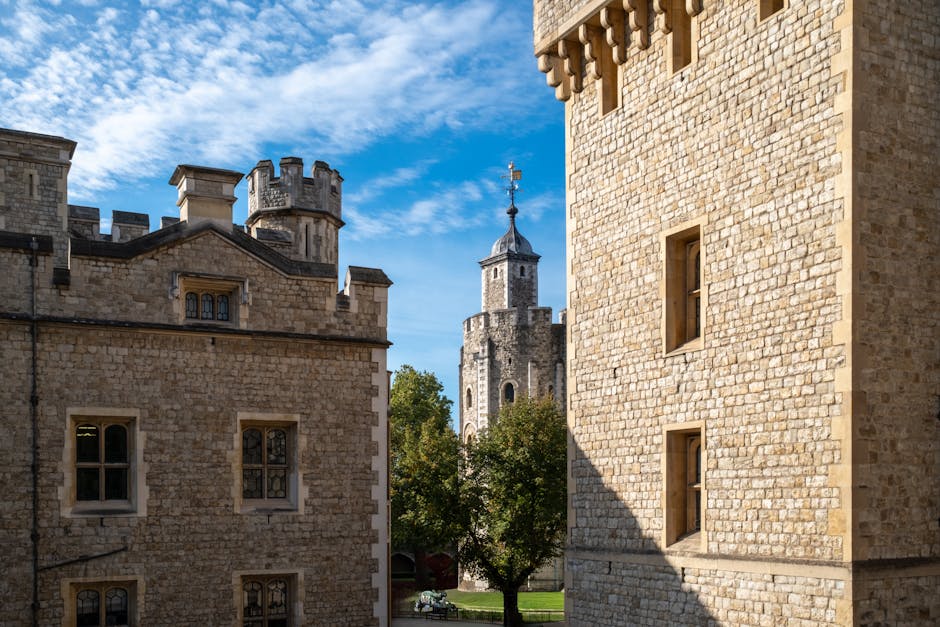A photograph of historic stone buildings with medieval architectural features, including small rectangular windows and crenellated battlements, captures the exterior of Lambeth Palace near Waterloo St